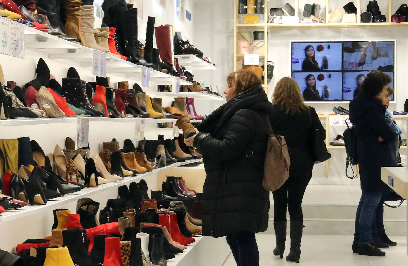 Una mujer observa varios productos en un comercio de Segovia.