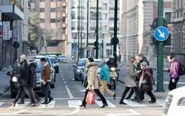 Varias personas cruzan un paso de cebra en la calle San Ildefonso.