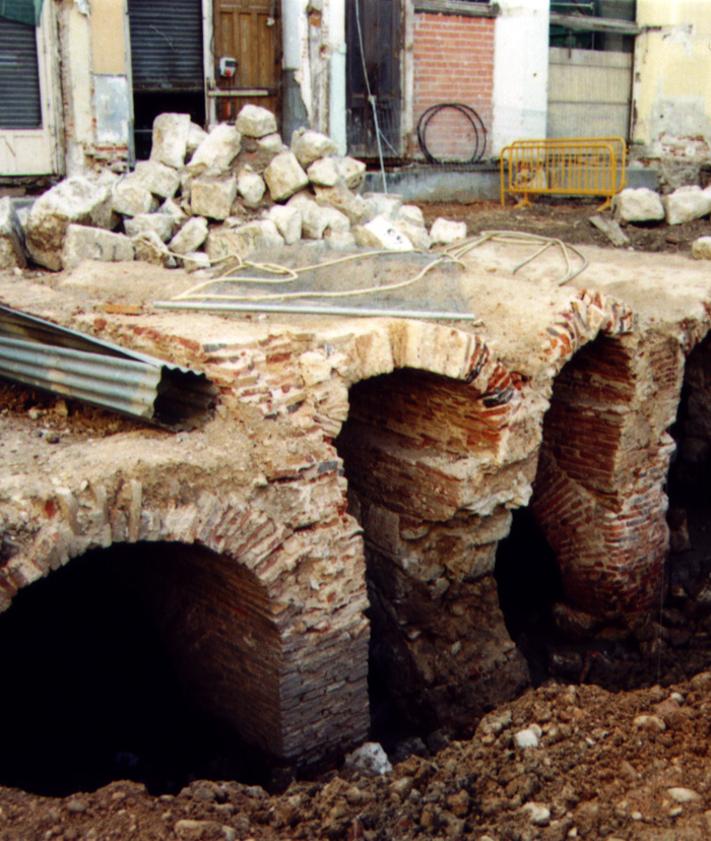 Imagen secundaria 2 - Arriba los dos ojos del puente durante las obras en los inmuebles del costado occidental de la calle, abajo a la izquierda el interior del arco septentrional del puente y a la derecha estructuras adosadas al puente por su lateral occidental.