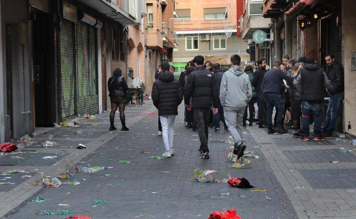 Jóvenes agotan los últimos momentos de la Nochevieja en el barrio de La Puebla de Palencia.