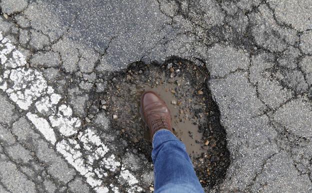 Uno de los peligrosos baches en la vía.