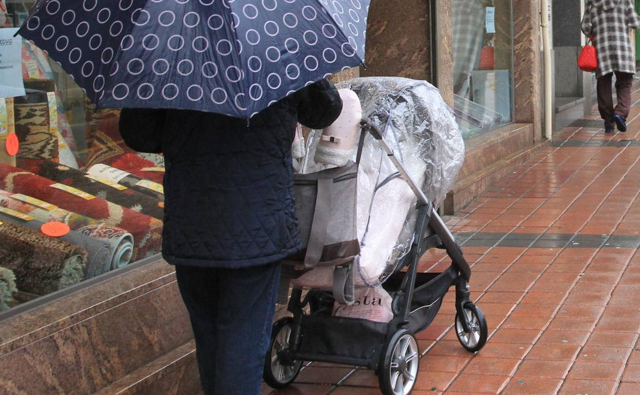 Una mujer empuja un carrito de bebé en una calle de Segovia. 