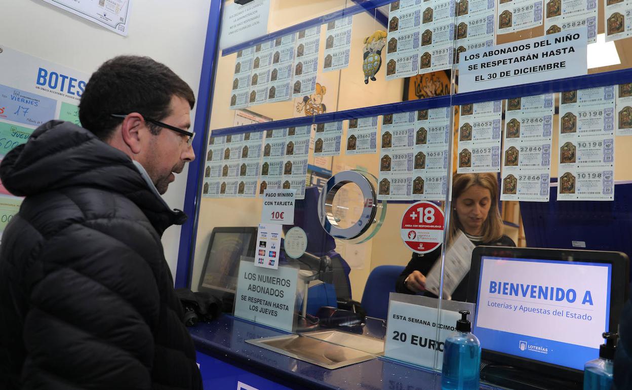Un hombre compra lotería en una administración palentina. 