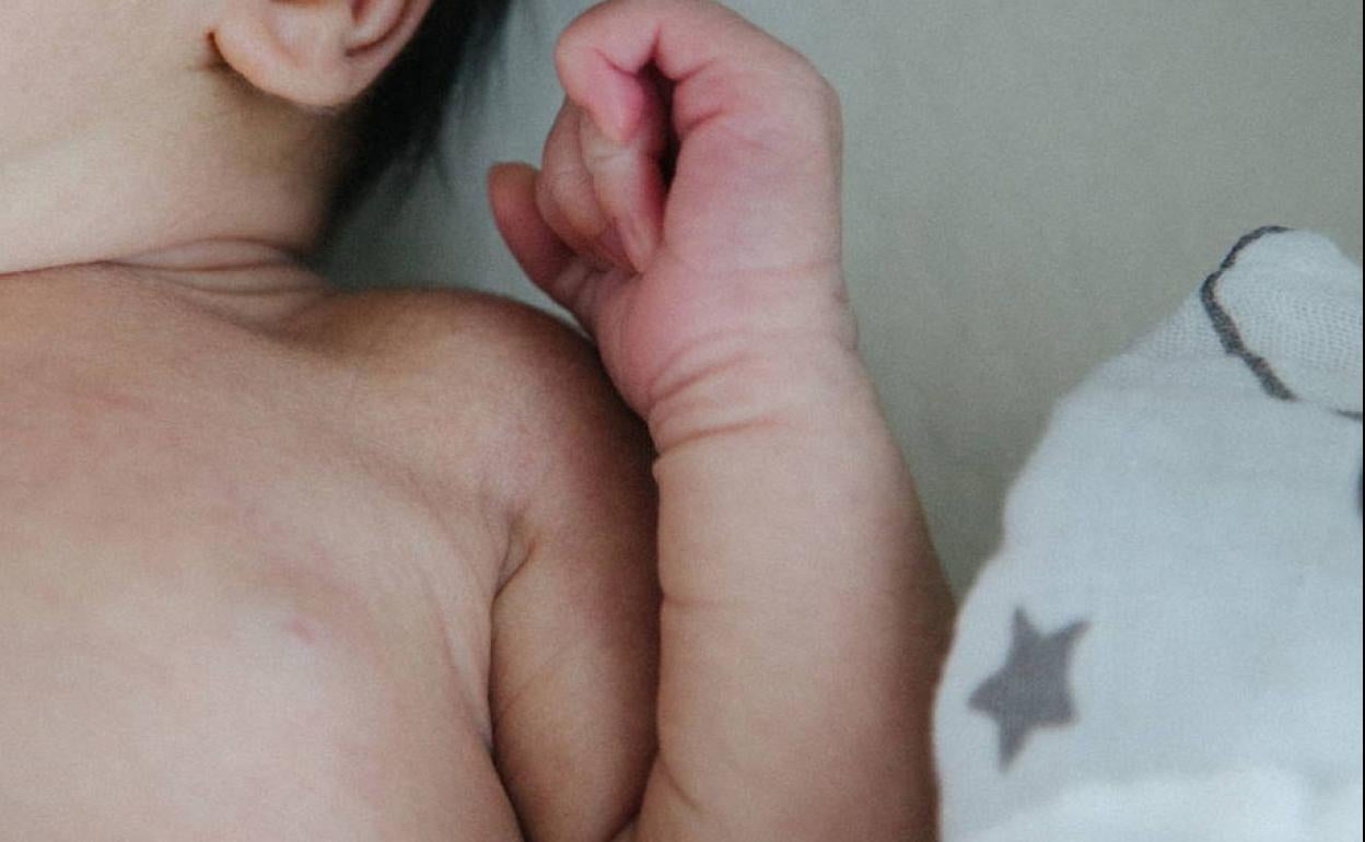 Un bebé descansa en su cuna.