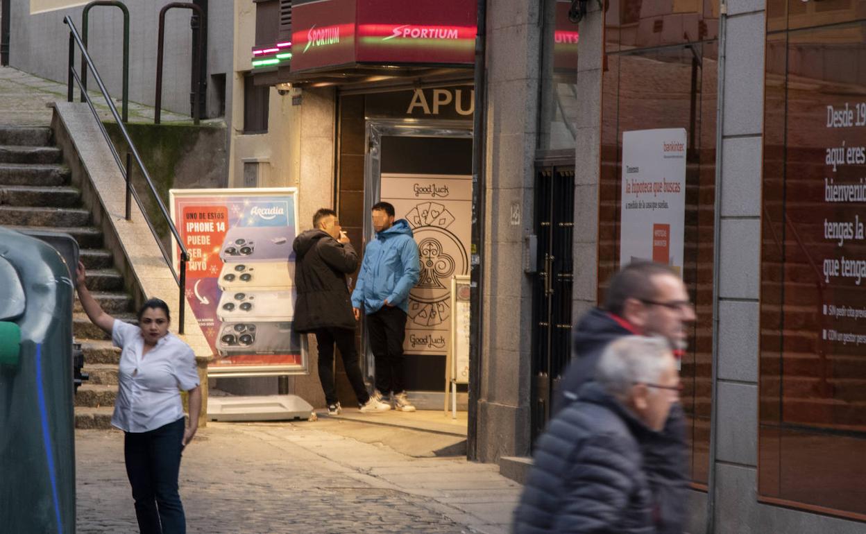 Dos jóvenes, a las puertas de una casa de apuestas de Segovia.