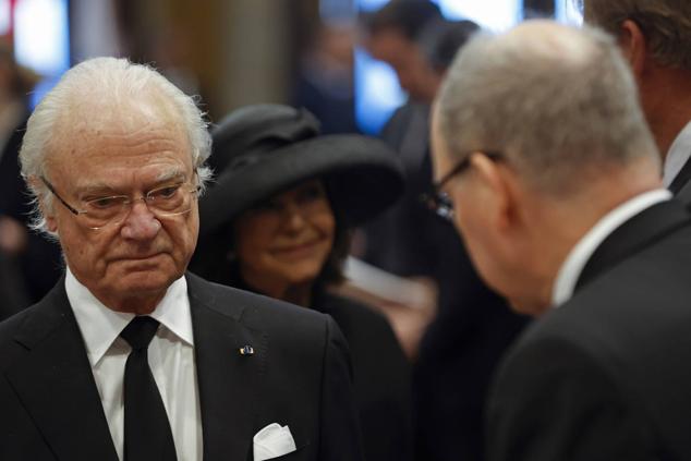 El rey Carlos Gustavo de Suecia y la reina Silvia saludan a Alberto II de Mónaco a su llegada al funeral.