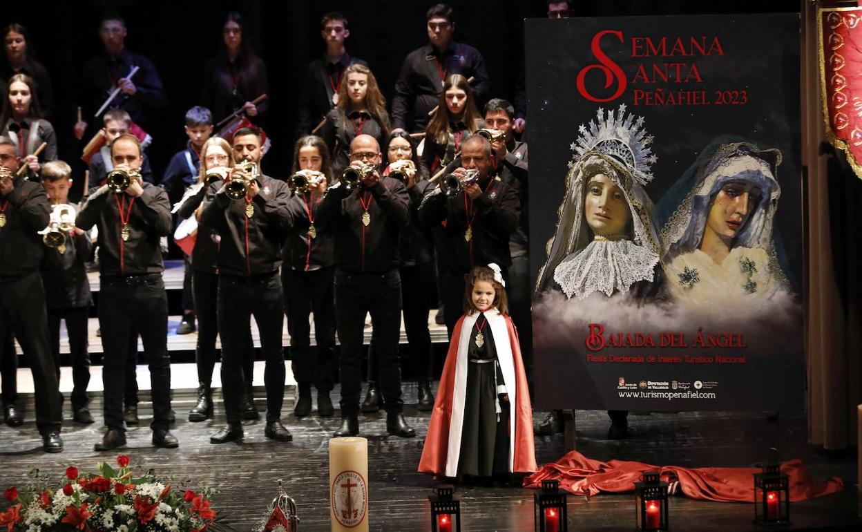 La pequeña Julia Arranz, que realizará la Bajada del Ángel, junto al cartel y la banda de la Pasión.