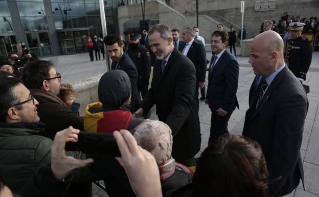 El rey saluda a una persona ataviada con una bandera de España.