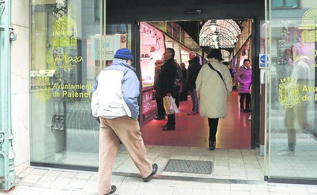 Varios clientes entran a comprar en el mercado. 