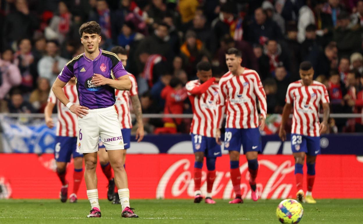 Aguado, con la mirada perdida y los jugadores del Atleti celebrando un tanto a su espalda. 