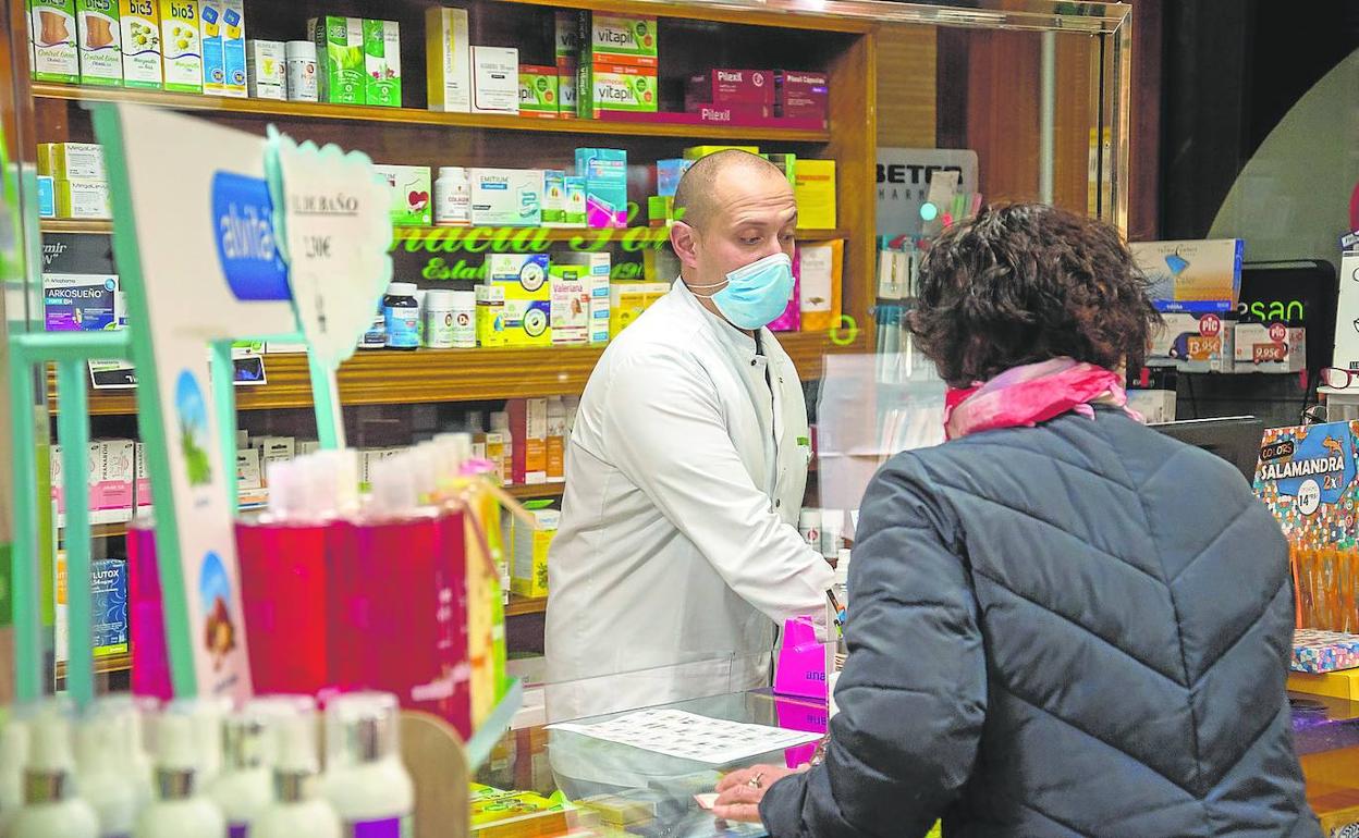 Una mujer es atendida en la farmacia de Modesto Lafuente, junto al centro de salud de La Puebla. 