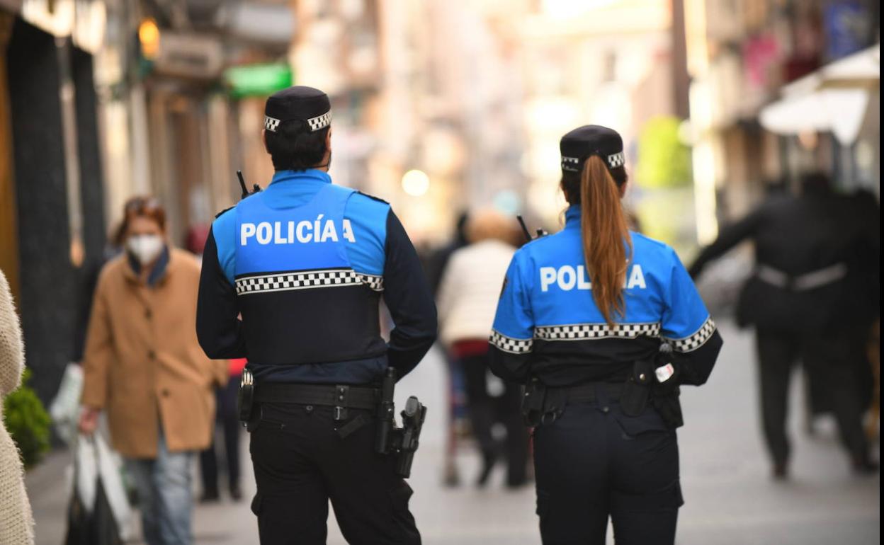 Dos agentes de la Policía Local patrullan por una calle de la ciudad. 