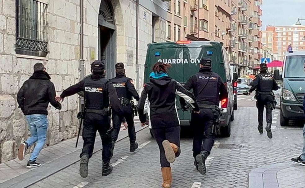 Familiares de las víctimas persiguen el furgón, escoltado por los agentes, que trasladó al detenido. 