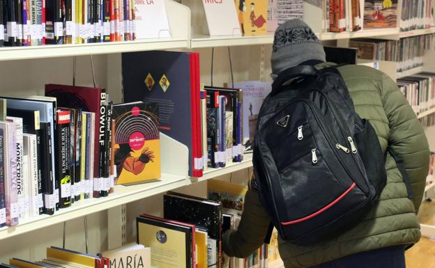 Un hombre coge un libro de la Casa de la Lectura.