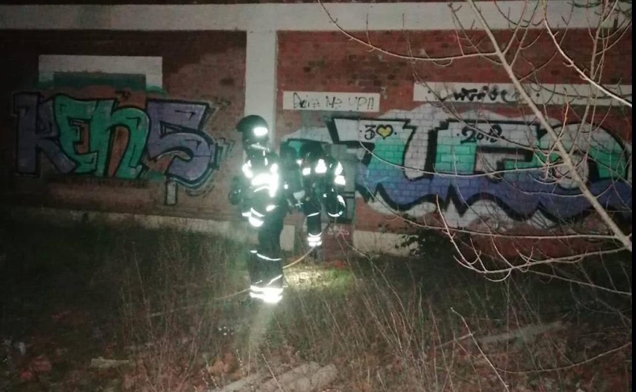 Un bombero con su equipo junto a un muro del chalé abandonado en una parcela residencial de la antigua azucareera. 