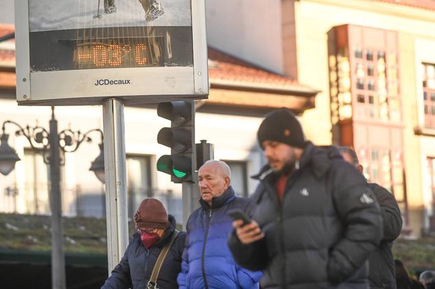 Viandantes fuertemente abrigados caminan en Plaza España mientras el termómetro marca tres grados bajo cero.