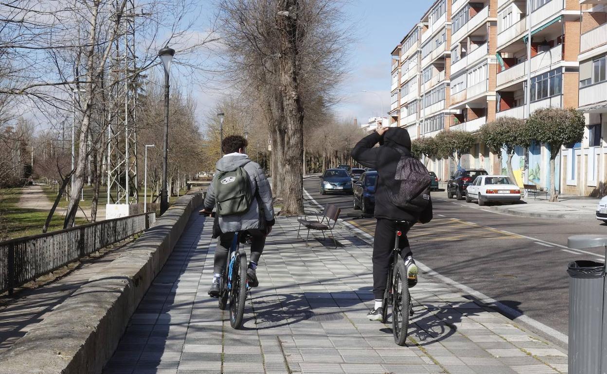 Dos ciclistas por la acera de la avenida de Castilla.