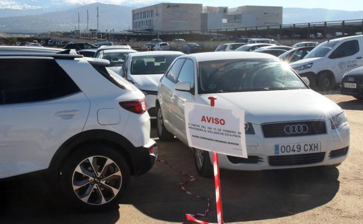 Un cartel avisa del inminente vallado del terreno privado donde ahora se aparca. 