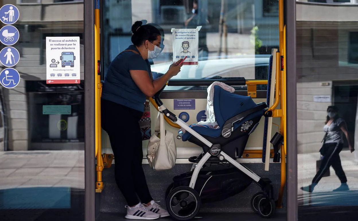 Una madre viaja con su bebé en un autobús urbano.