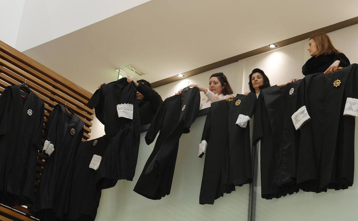 Tres letradas cuelgan sus togas en el edificio del Palacio de Justicia en señal de protesta. 