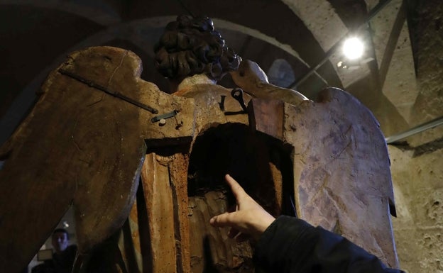 Hueco en la espalda de San Miguel donde han aparecido dos cuartillas de papel que parecen ser una carta. 