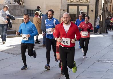 Imagen secundaria 1 - Arriba, los tres primeros de la prueba, con Álvaro Conde, el ganador, en el centro; abajo, corredores en la Calle Real y a la derecha, uno de los participantes saluda al público que animaba en este tramo. 