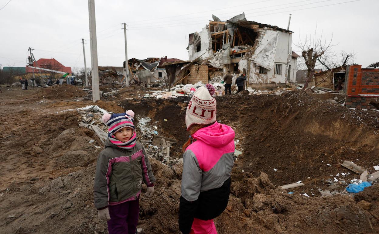 Dos niños ucranianos observan las casas destruidas por los bombardeos rusos en Hlevakha, cerca de Kiev. 