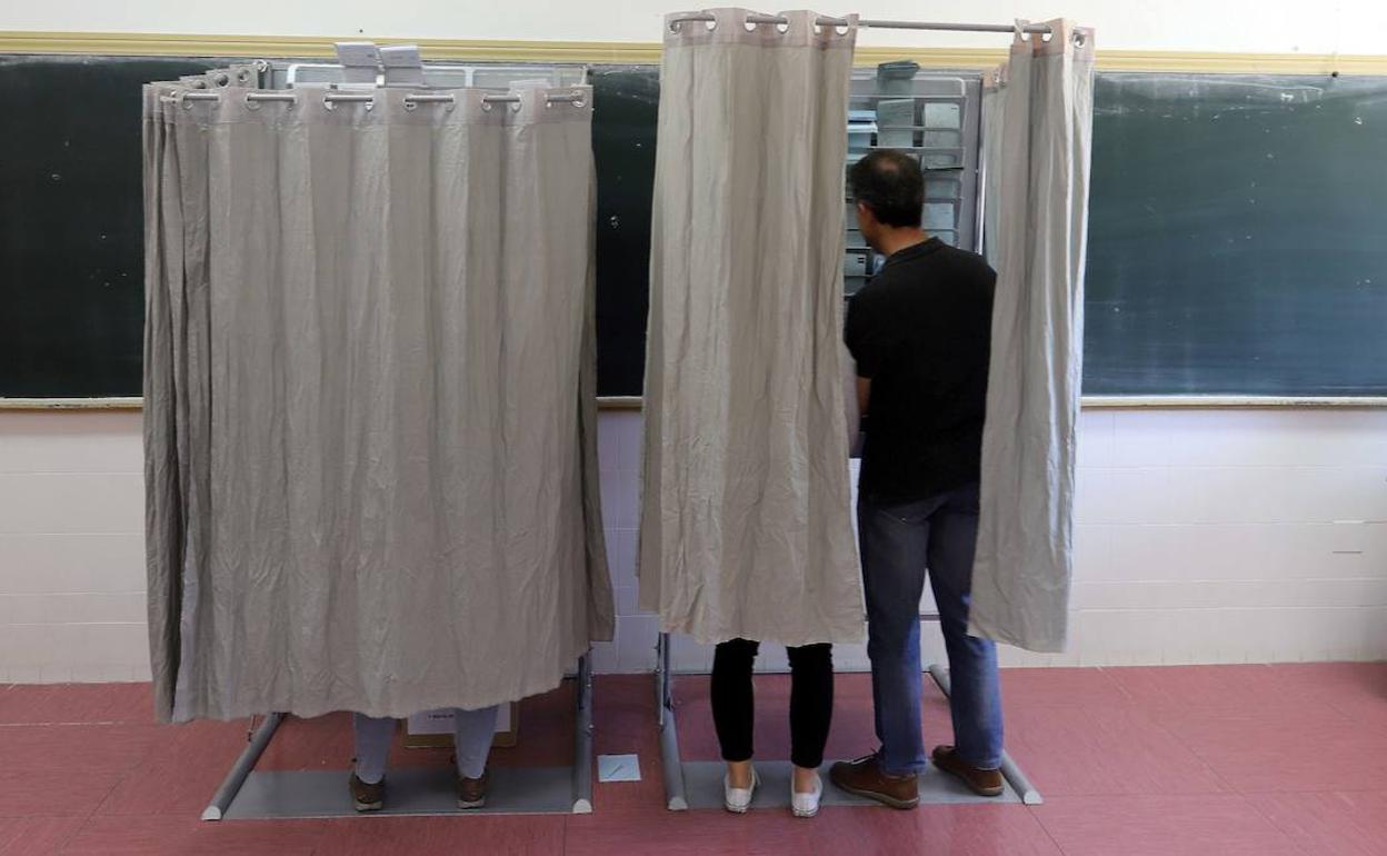 Algunos votantes escogen sus papeletas en la jornada de votación del 26 de mayo de 2019, en Valladolid. 