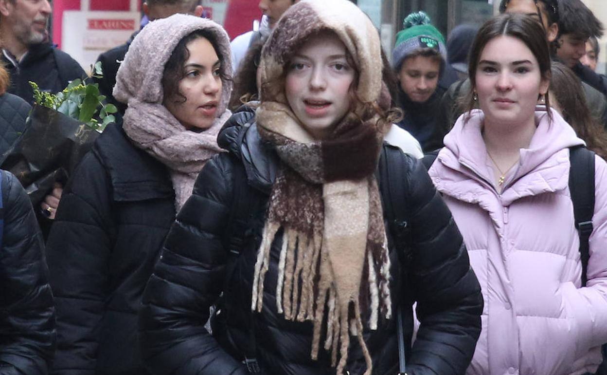 Jóvenes pasean abrigadas por Segovia ante la entrada de aire frío, este miércoles. 