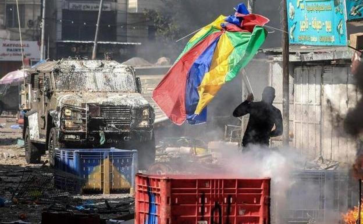 Un palestino se enfrenta con una sombrilla a uno de los blindados israelíes.