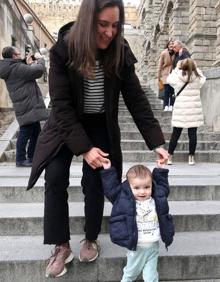 Imagen secundaria 2 - Arriba, Emma juega con un peluche. Abajo, junto a sus padres a los pies del Acueducto. A la derecha, la bebé baja las escaleras del Postigo con la ayuda de su madre. 
