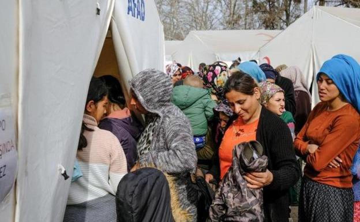 Víctimas del terremoto hacen cola para recibir ayuda en un campamento de tiendas de campaña en la localidad turca de Kahramanmaras.