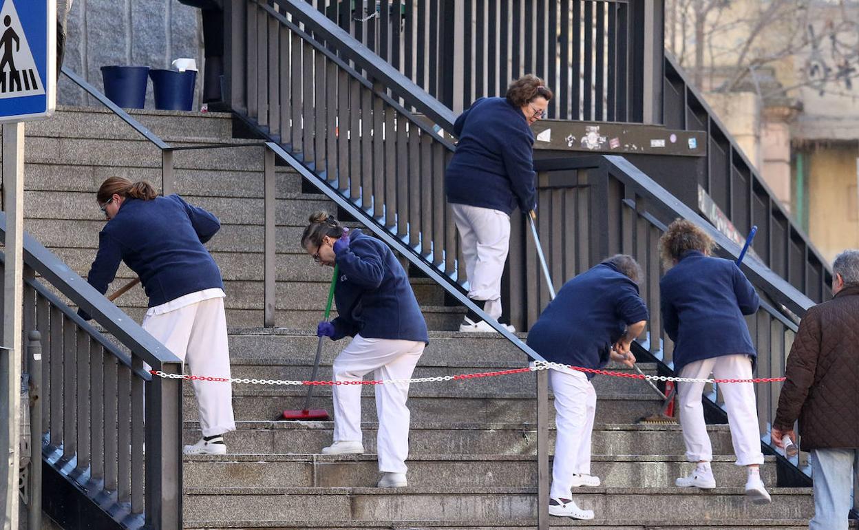 Un grupo de trabajadoras limpian la entrada al campus de la UVA en Segovia. 