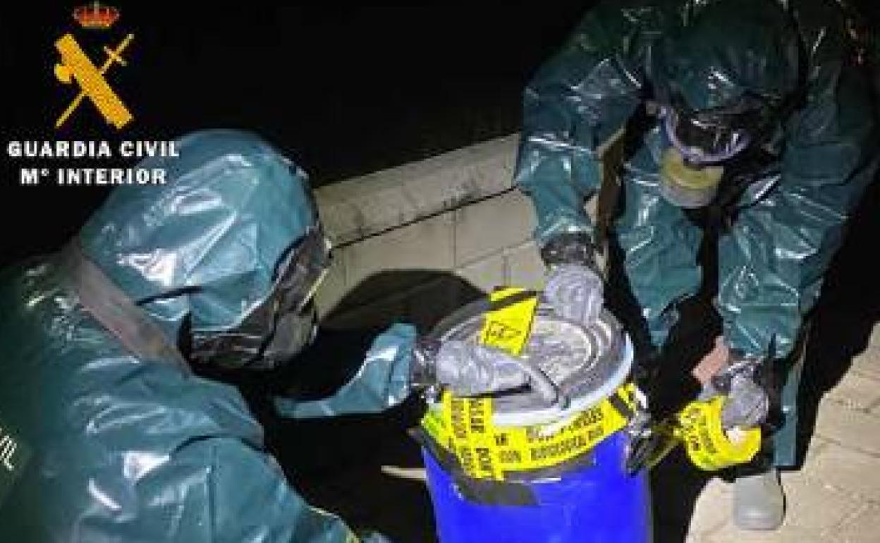 Agentes de la Guardia Civil manipulan una de las garrafas. 