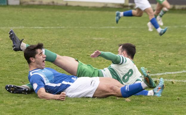 Adri y un rival se lanzan al suelo para pelear un balón dividido.