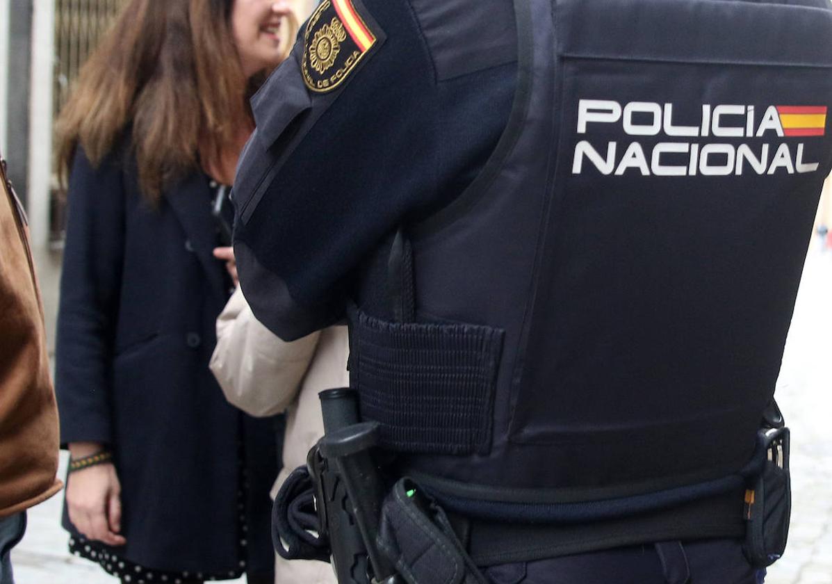 Un agente de la Policía Nacional junto a unos transeúntes en Segovia.