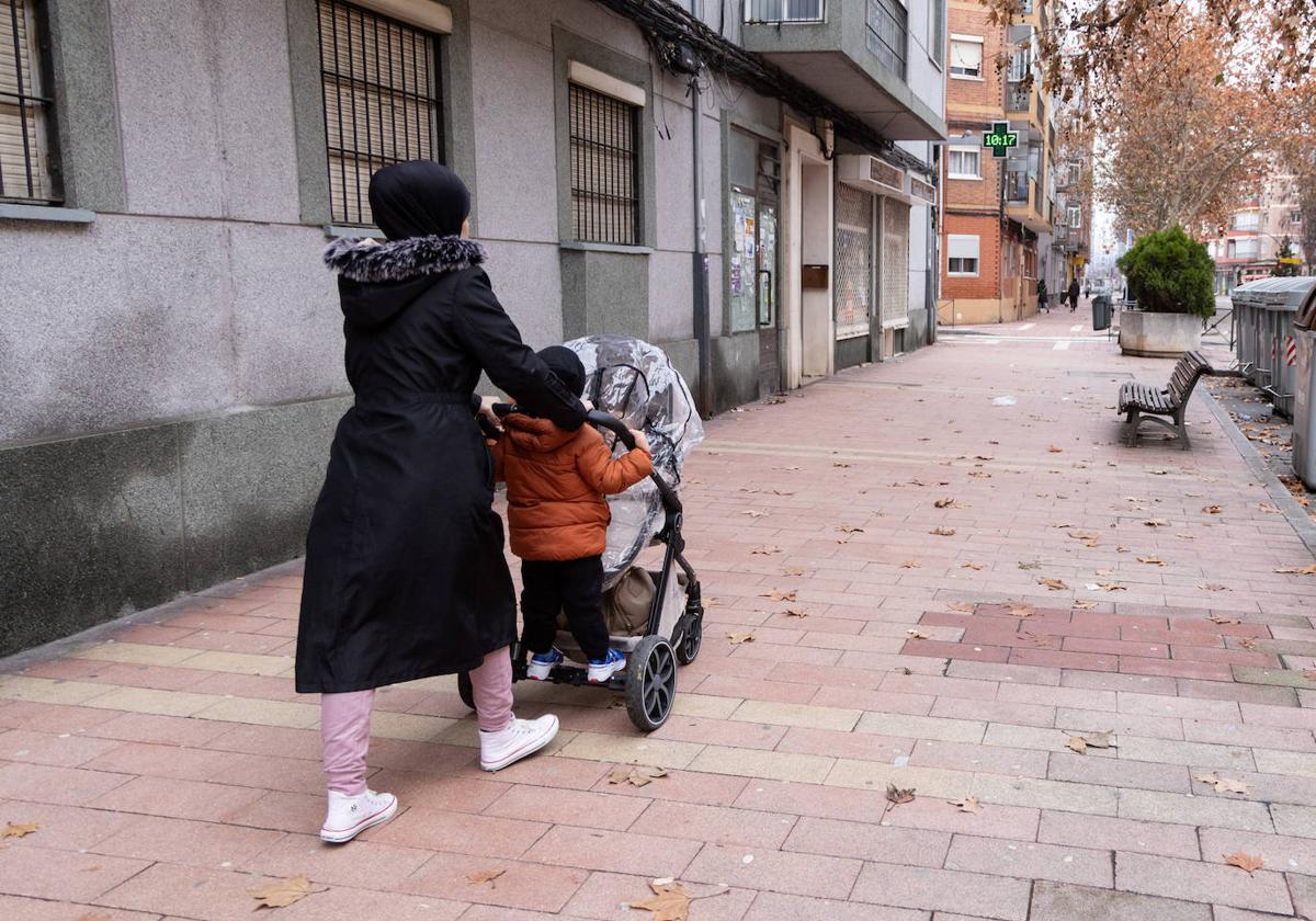 Una mujer pasea con dos niños por las Delicias.