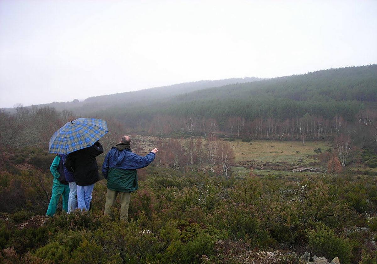 Tres personas observan un paraje de Robleda-Cervantes.