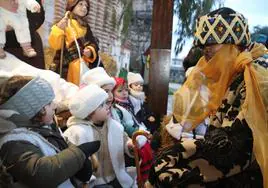Niños con cara de asombro al saludar a Baltasar en la visita de los Reyes Magos a Cuéllar.