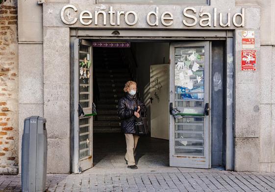 Una mujer sale con mascarilla de un Centro de Salud.