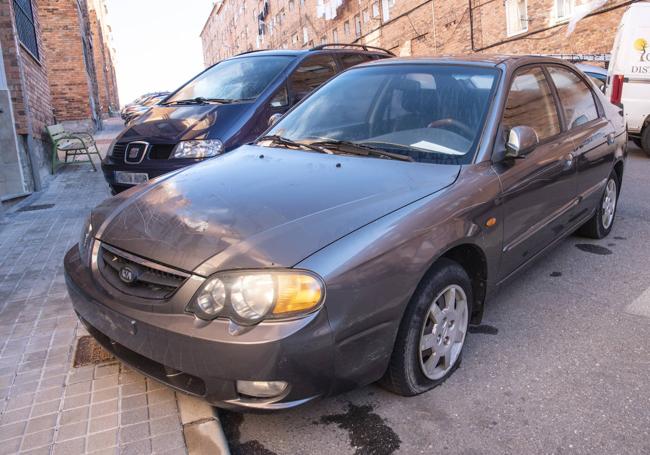 Vehículo abandonado en la calle Malangosto, con las ruedas sin aire y sin placas de matrícula.