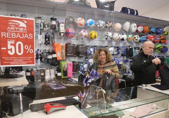 Trabajadores de Deportes Artiza, en Palencia, atienden unas compras el primer de rebajas de invierno.