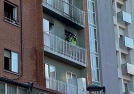 Bomberos en el balcón de la vivienda afectada por el incendio.