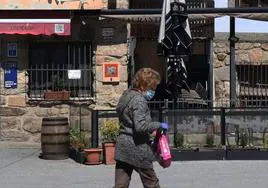 Una mujer pasa por delante del restaurante Lobiche, en Navafría, que ha repartido tres décimos del primer premio de la Lotería de este sábado.