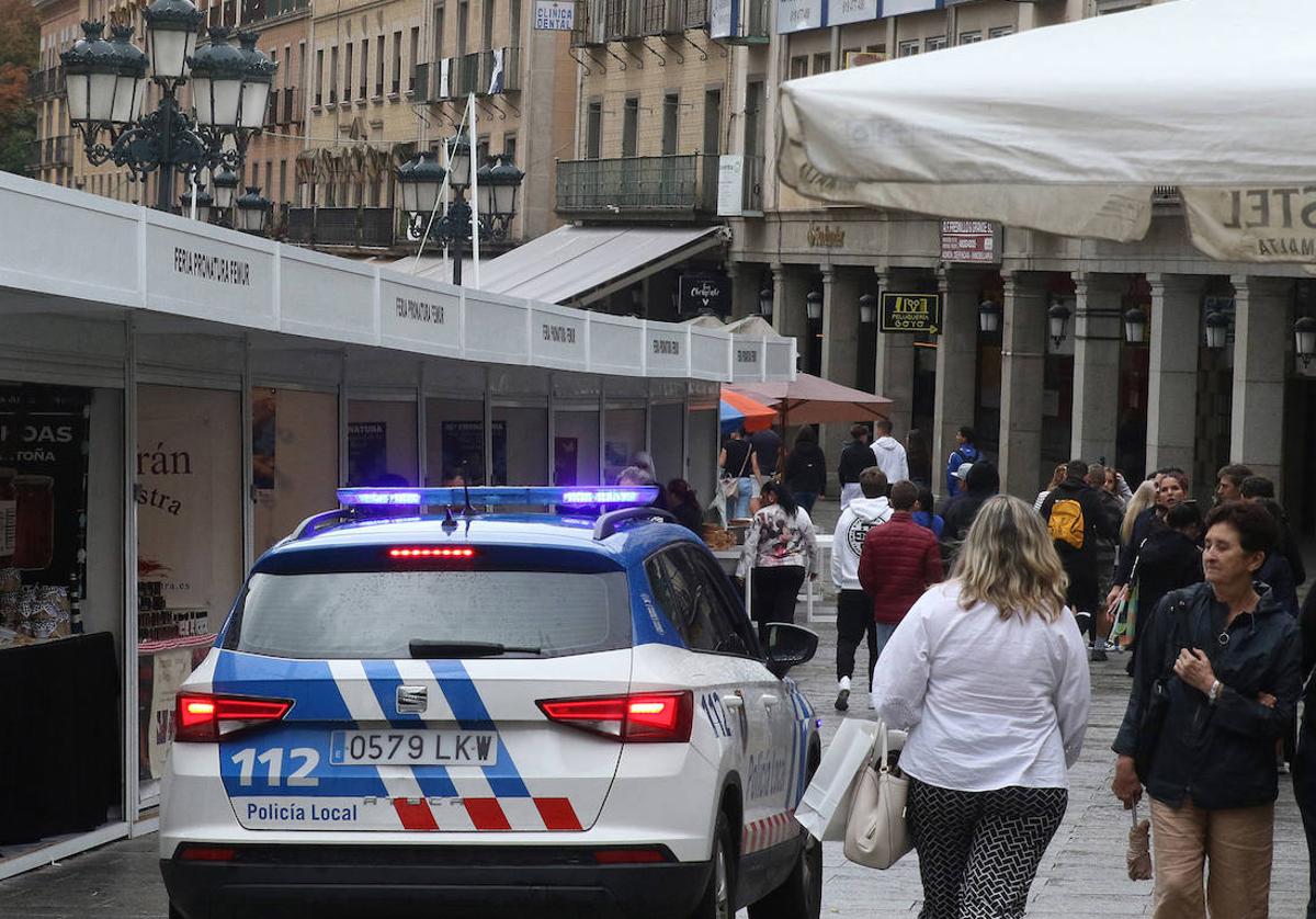 Un coche de la Policía Local patrulla por la avenida del Acueducto durante una feria.