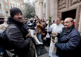 El párroco de la iglesia de El Salvador bendice una de las mascotas