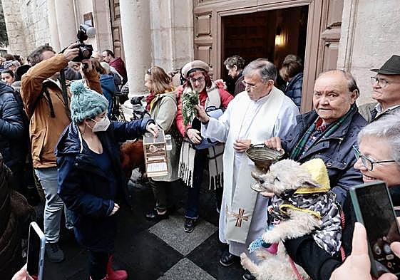 Una mujer sujeta a su perro dentro de templo de El Salvador.
