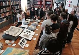 Una técnica de la Biblioteca Nacional muestra ejemplares restaurados durante una visita guiada.