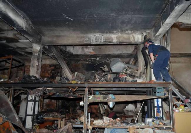 Un bombero inspecciona el interior del inmueble.