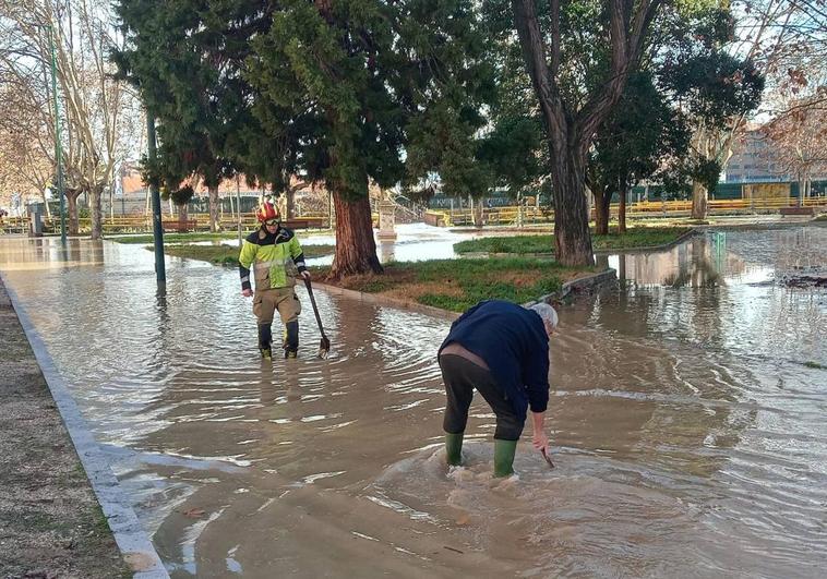 Bomberos y operarios intentan desatascar el alcantarillado para aliviar la inundación.